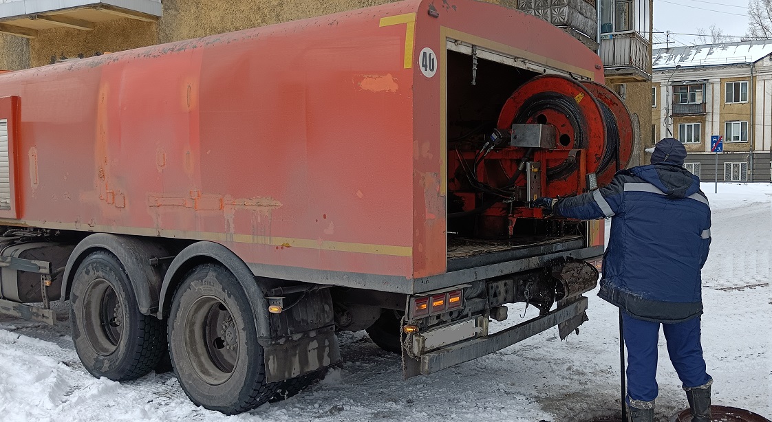 Каналопромывочная машина и работник прочищают засор в канализационной системе в Феодосии